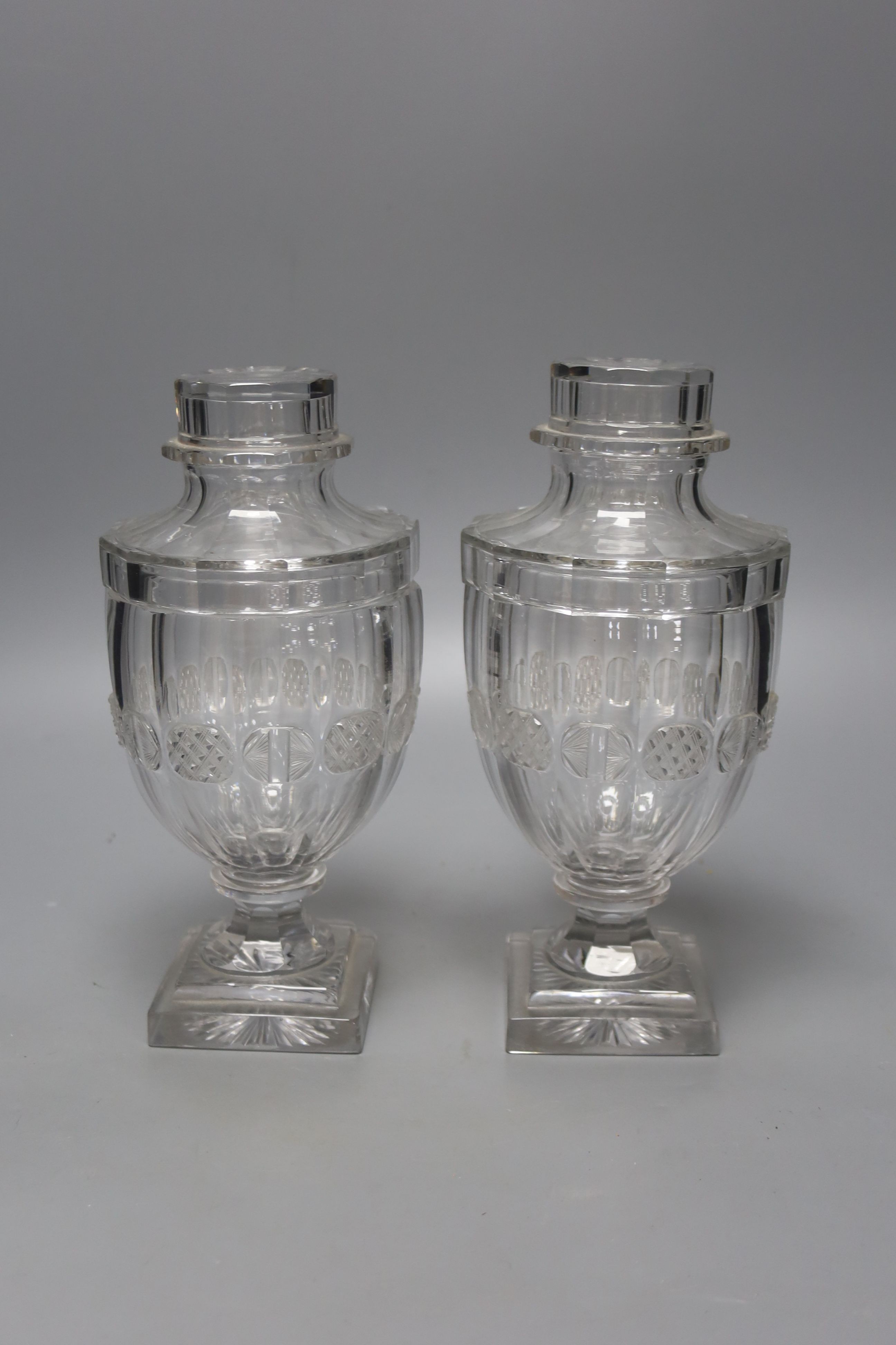 A pair of Victorian cut glass urns and covers